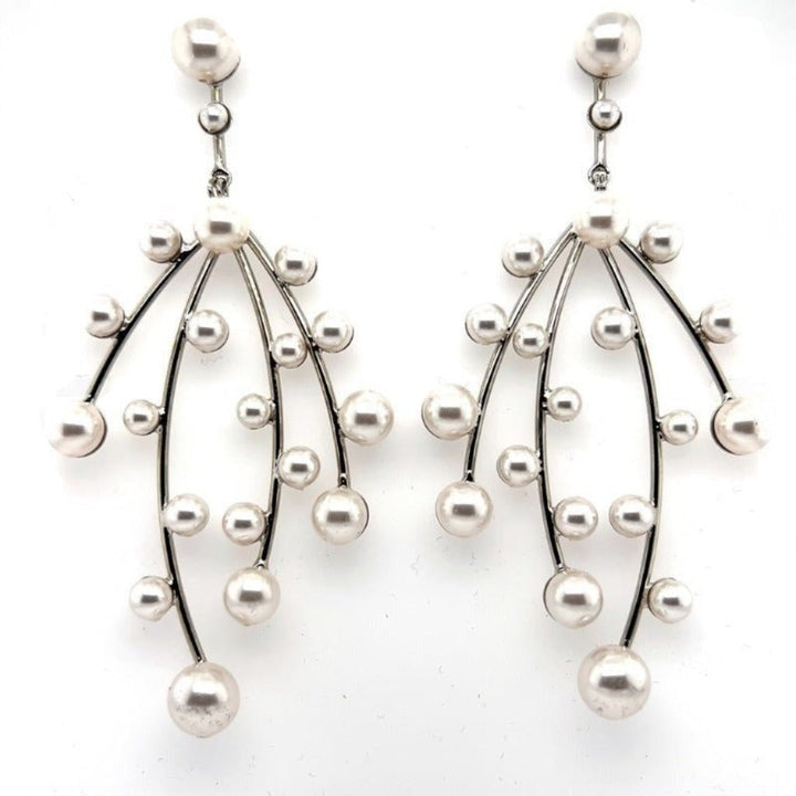 The Modern Pearl Chandelier Earrings (style no. E216) feature three curved silver branches on each piece, adorned with genuine pearls for an elegant, modern look—perfect as sophisticated bridal earrings.
