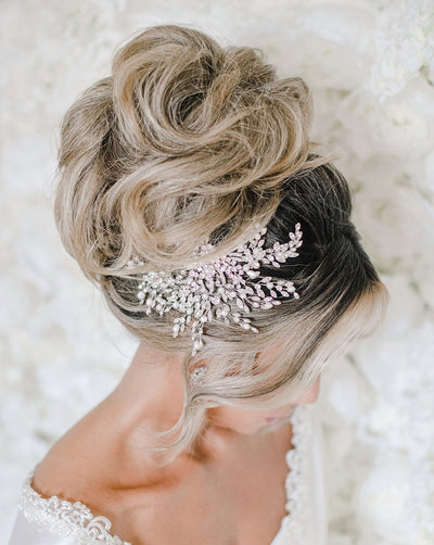 hair comb with round silver detailing surrounded by sweeping branches of crystals and pearls on a bridal updo