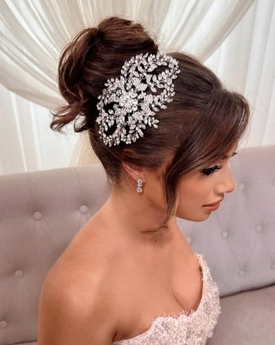 female model wearing silver bridal hair comb with floral detailing and rounded sprays of oval crystals