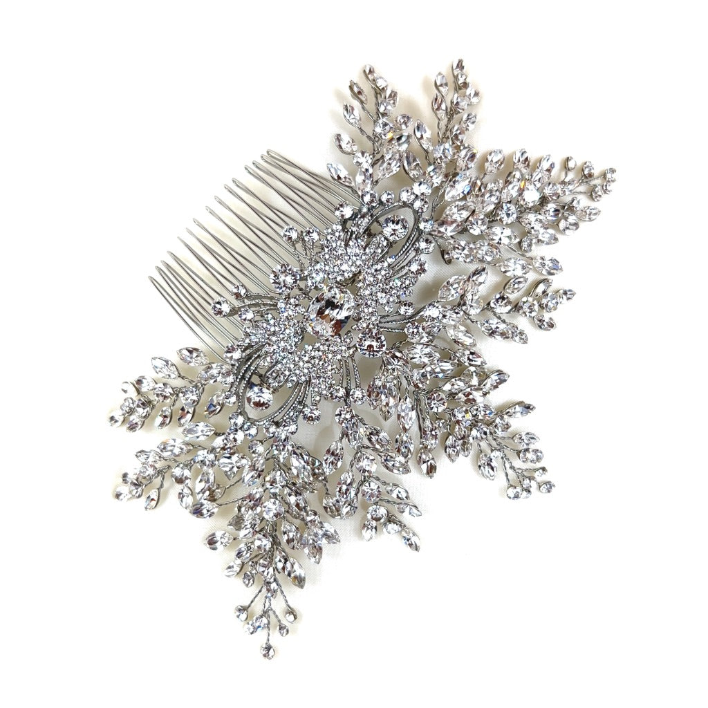 bridal hair comb with single crystal at its center surrounded by round silver detailing and sprays of crystals