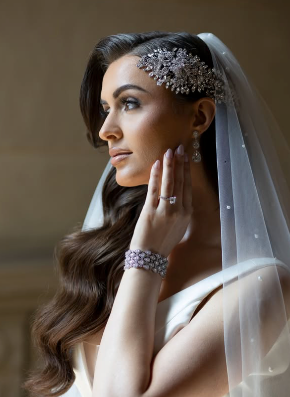 Bride with side-swept old Hollywood waves wearing a crystal bridal hair vine, bridal bracelet, and veil
