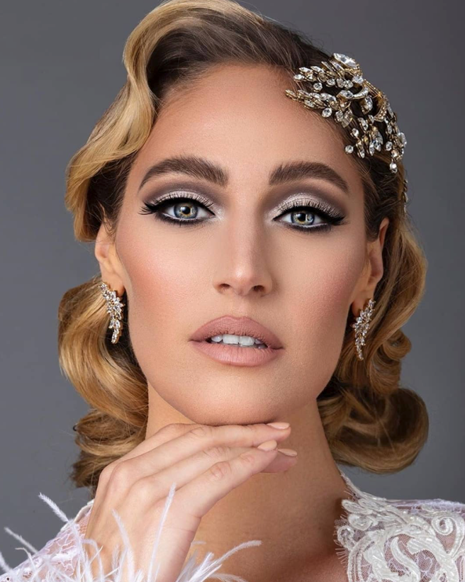 Glamorous bride with styled bob haircut wearing an ornate crystal hair comb and matching drop earrings, showcasing elegant bridal accessories for short hair