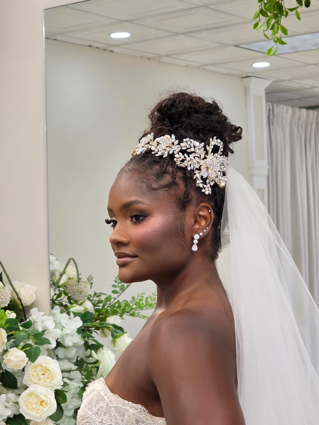 Bride wearing a gold crystal and pearl bridal hair vine with a high updo and wedding veil at Bridal Styles Boutique in New York