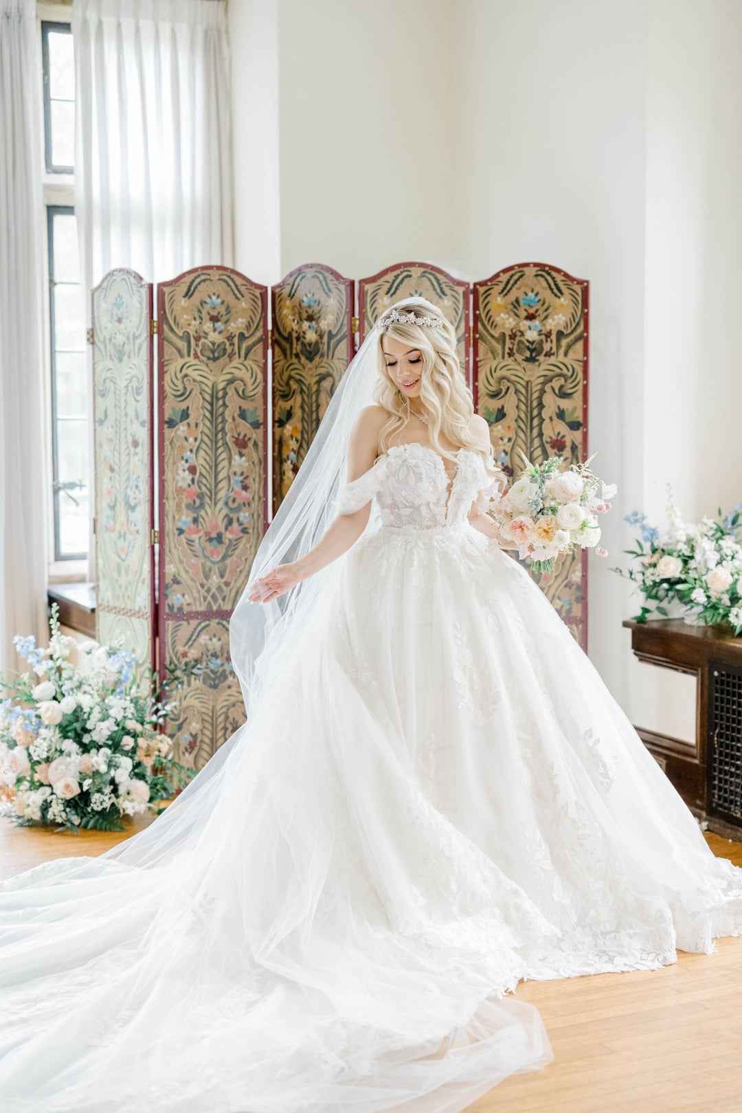 Bride wearing a crystal floral tiara, wedding necklace, and cathedral veil in her off the shoulder ball gown at Parque at Ridley Creek