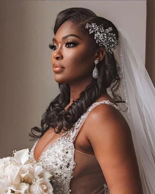 Stunning bride with half up half down wedding hairstyle featuring crystal hair comb, drop earrings, and cathedral veil