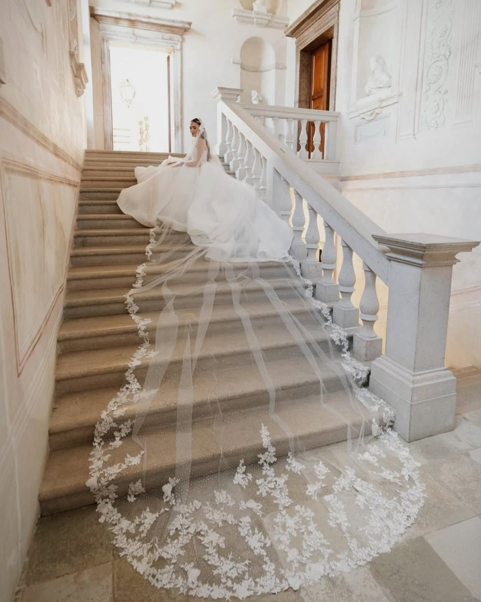 Bride Stephanie descending grand staircase in custom crystal-encrusted lace-edge royal cathedral veil and ballgown