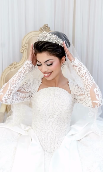 Joyful bride wearing Swarovski crystal wedding tiara with cathedral veil and polished updo