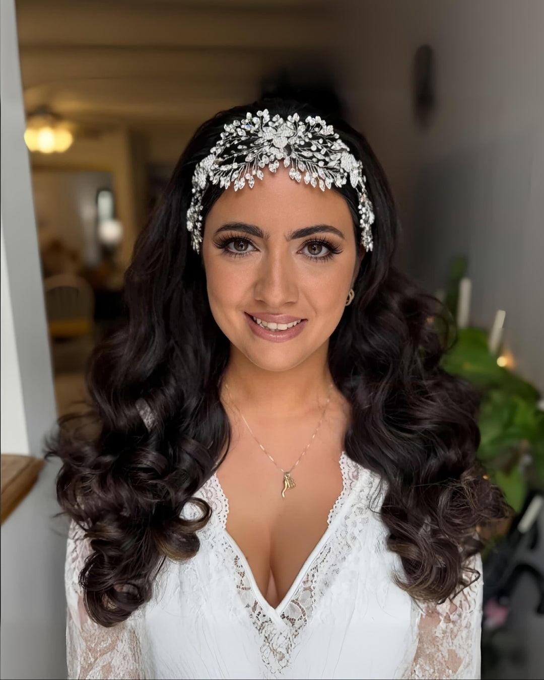 Dark hair bride with long flowing curls wearing a stunning dramatic crystal face framing bridal headpiece