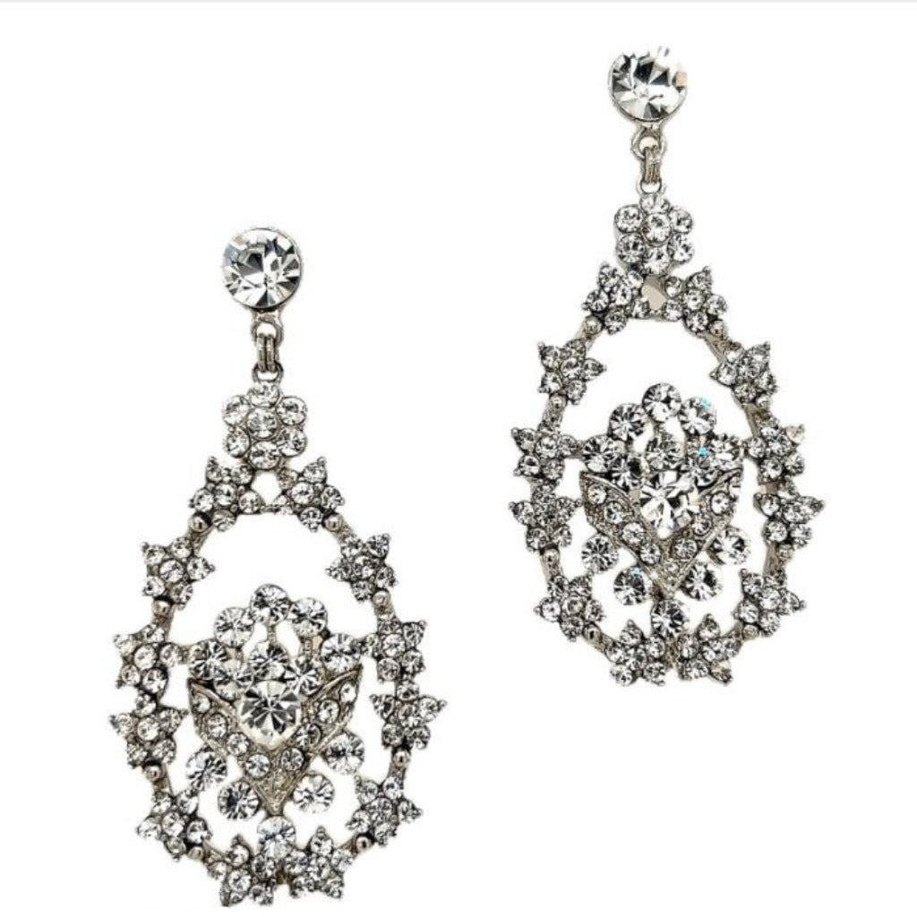 Close-up of Swarovski crystal chandelier earrings with an open teardrop design and floral-inspired detailing in silver-tone metal.