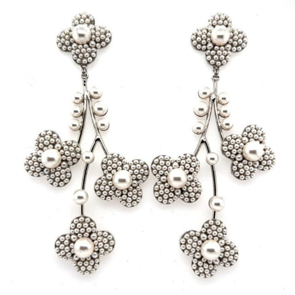The Pearl Blossom Chandelier Earrings (style no. E217) feature five-petal floral clusters with beaded textures and real pearls, linked by curved stems and beads—an elegant choice for bridal wear.