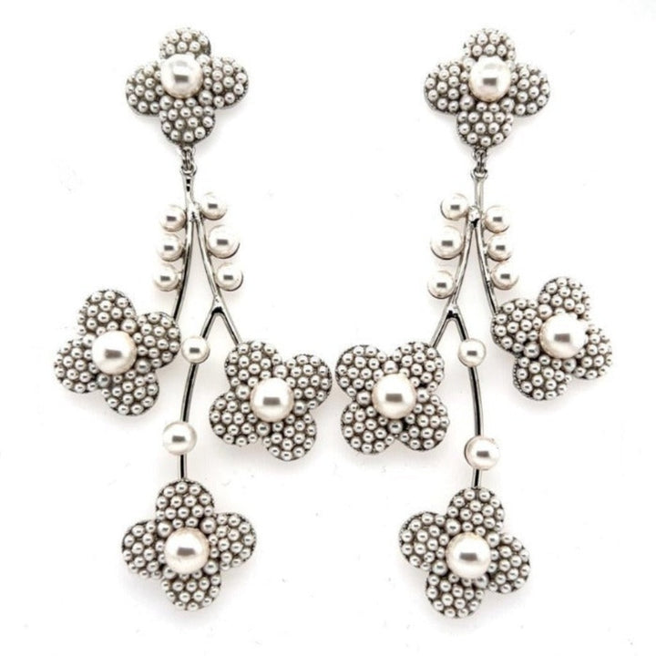 The Pearl Blossom Chandelier Earrings (style no. E217) feature five-petal floral clusters with beaded textures and real pearls, linked by curved stems and beads—an elegant choice for bridal wear.