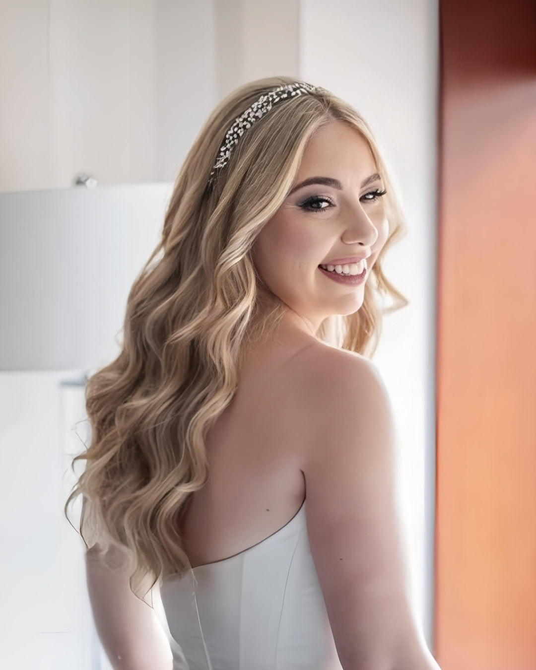 Blond bride with long flowing curls wearing a Swarovski  crystal vine headpiece by Bridal Styles Boutique