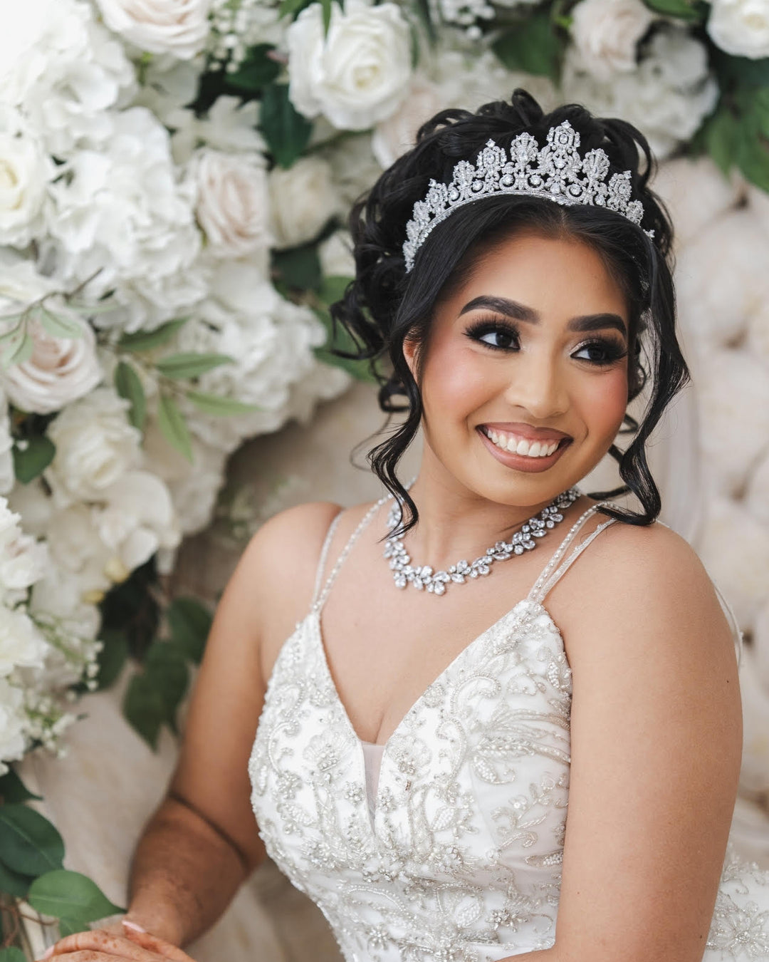 Beautiful dark hair bride with updo wearing crystal bridal tiara and wedding jewelry 