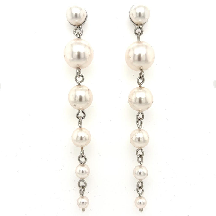 The Pearl Drop Earrings (style no. E214) feature five graduated pearls linked vertically on each silver-tone earring, with a delicate chain design. The pearls decrease in size from top to bottom for an elegant bridal look.