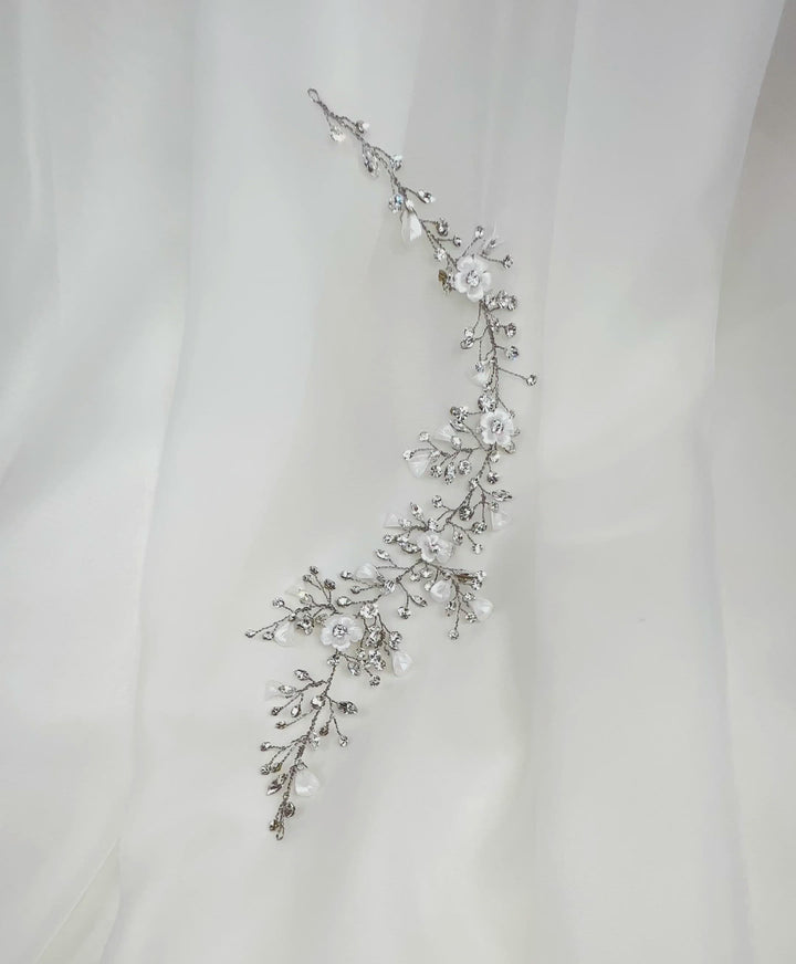 A lovely bridal hair vine  inspired by a floral garland  with small crystal sprigs and porcelain flowers