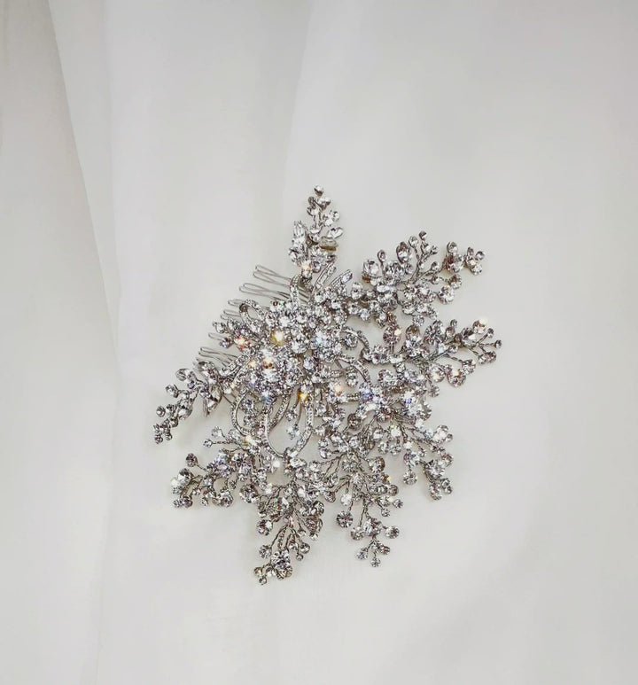 bridal hair comb with circling silver details at its center and branches of round, sparkling crystals