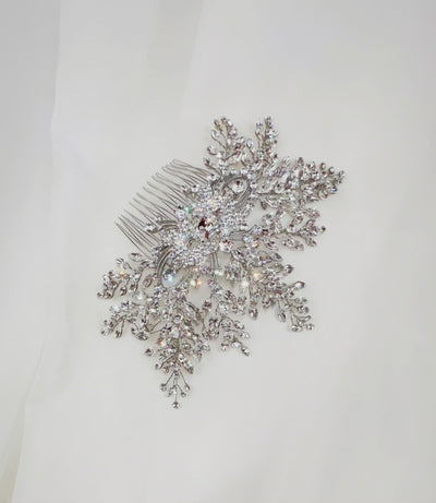 bridal hair comb with single crystal at its center surrounded by round silver detailing and sparkling sprays of crystals