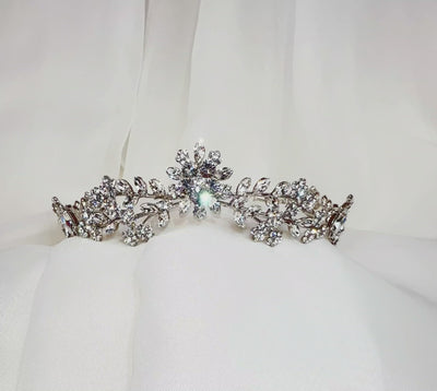 silver bridal tiara with crystal flower at its center with smaller crystal leaves and sparkling floral details