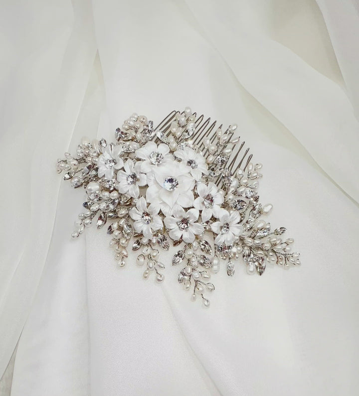 Video of a pearl and crystal bridal hair comb sparkling in the light as it is slowly rotated on soft ivory fabric