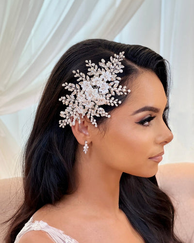 female model wearing white porcelain flower bridal hair comb surrounded by long sprays of crystal and pearl