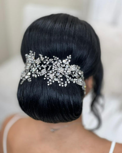 Bride wearing wide looping hair vine with crystal branches and floral details above an updo