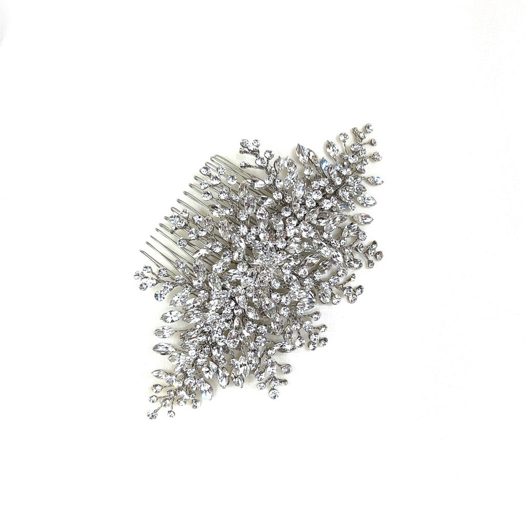 The Classic Bridal Comb, style no. 242646, features floral-inspired clusters of sparkling rhinestones in a symmetrical design on a plain white background, evoking the delicacy of a Swarovski creation.