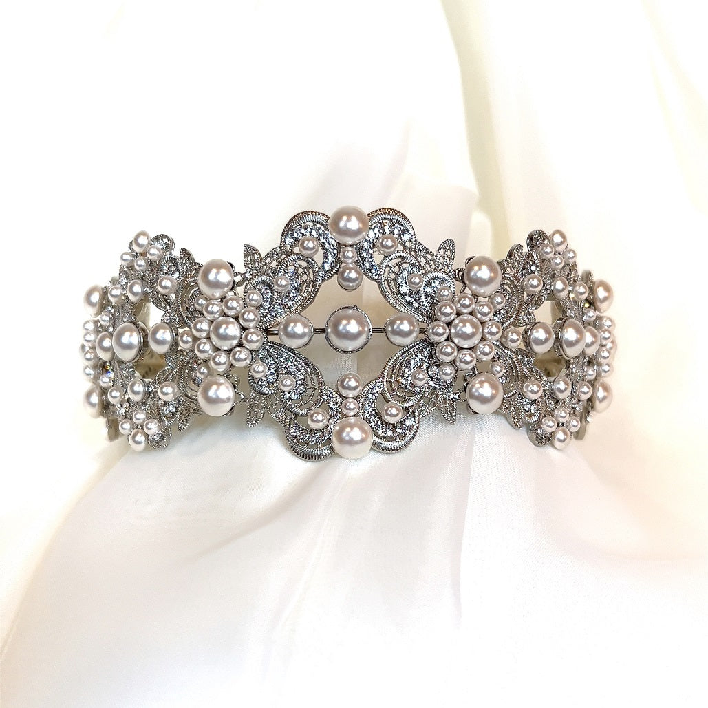 The Glamorous Pearl and Swarovski Crystal Bridal Headband (Style no. 392591) rests on soft white fabric, adorned with intricate designs and pearl clusters.