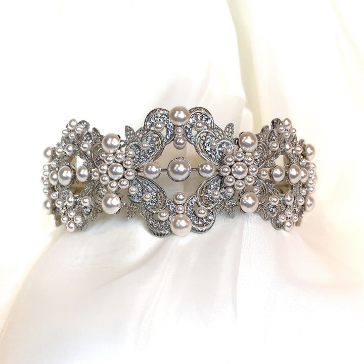 The Glamorous Pearl and Swarovski Crystal Bridal Headband (Style no. 392591) rests on soft white fabric, adorned with intricate designs and pearl clusters.