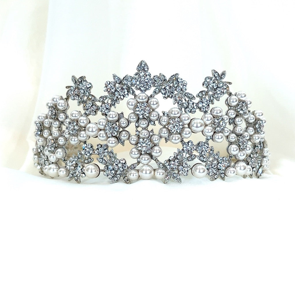 The Pearl and Swarovski Crystal Wedding Tiara, style no. 80044, is a sparkling bridal headpiece featuring intricate patterns of pearls and Swarovski crystals on a soft white base, exuding an elegant vibe.