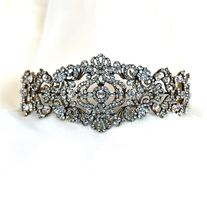 The Vintage Inspired Swarovski Crystal Headband, style no. 80107, is an ornate and statement-making bridal headpiece featuring intricate, vintage-inspired motifs. 