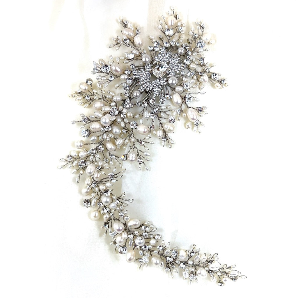 The Dramatic Asymmetrical Pearl and Crystal Vine (style no. 242703) forms a delicate, swirling design with intricate branches of small pearls and Swarovski crystals on a plain white background.