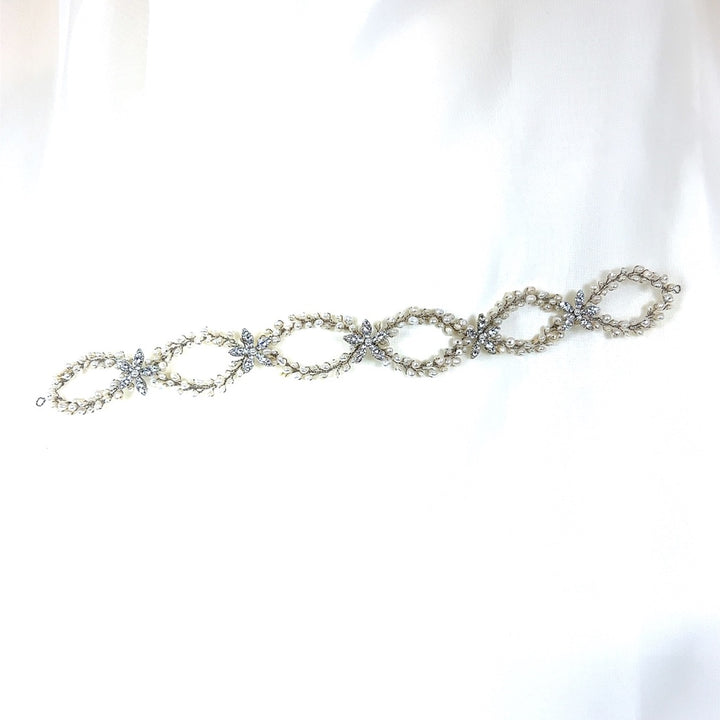 The Classy Pearl and Flower Looping Vine style no. 242708 is a delicate Swarovski crystal bridal headpiece  with interlocking oval links adorned with small, lustrous pearls and dazzling crystals  that embodies elegance.