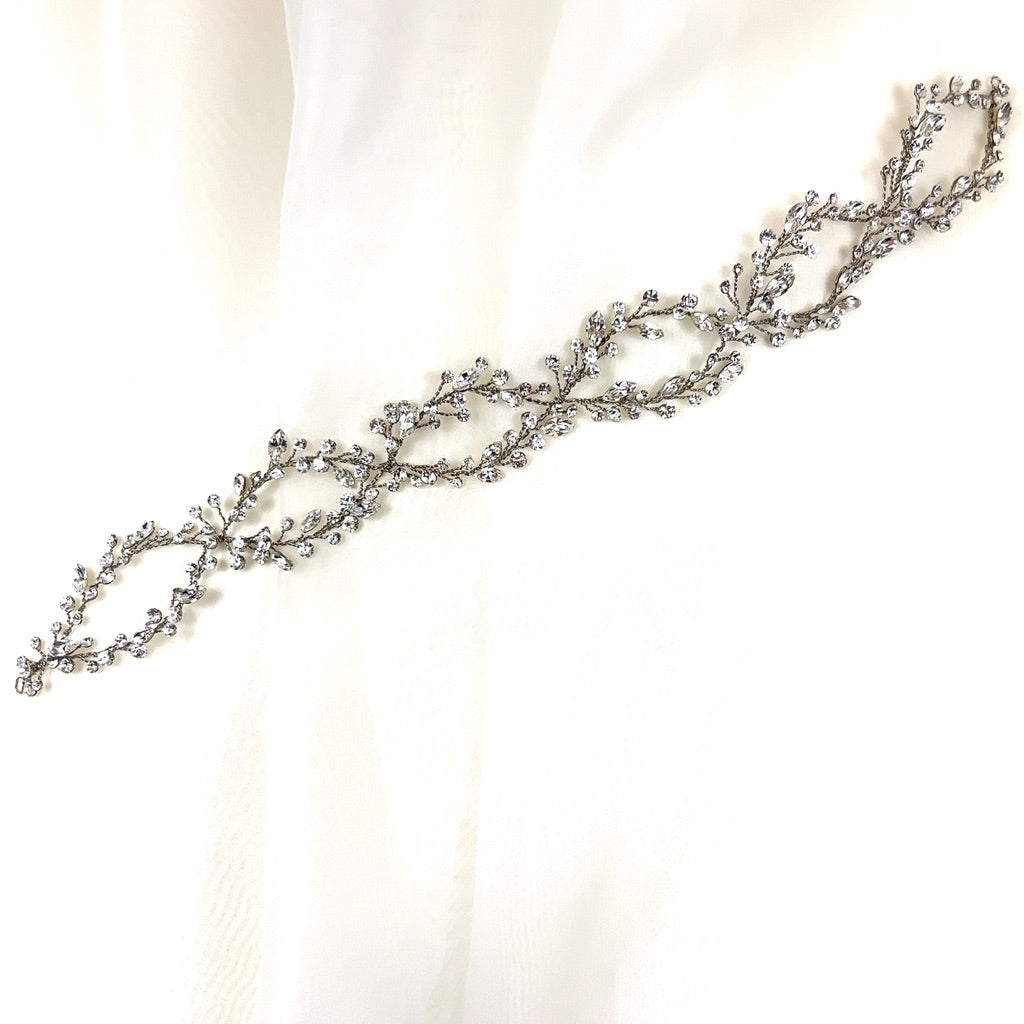 The Elegant Looping Bridal Vine (style no. 39228878) is a delicate Swarovski crystal wedding hair accessory featuring intricate leaf and vine designs adorned with small sparkling crystals.