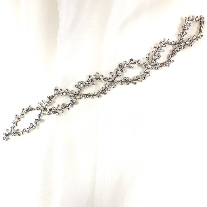 The Elegant Looping Bridal Vine (style no. 39228878) is a delicate Swarovski crystal wedding hair accessory featuring intricate leaf and vine designs adorned with small sparkling crystals.