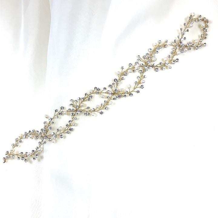 The Elegant Looping Bridal Vine (style no. 39228878) is a delicate Swarovski crystal wedding headpiece with intertwined branches adorned with pearls and crystals.