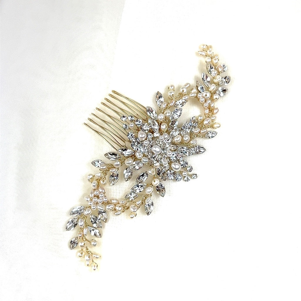 The Flowing Cluster Hair Comb, style no. 242514, is a bridal accessory with intricate floral designs adorned with genuine crystals and small pearls, set against a plain white background.