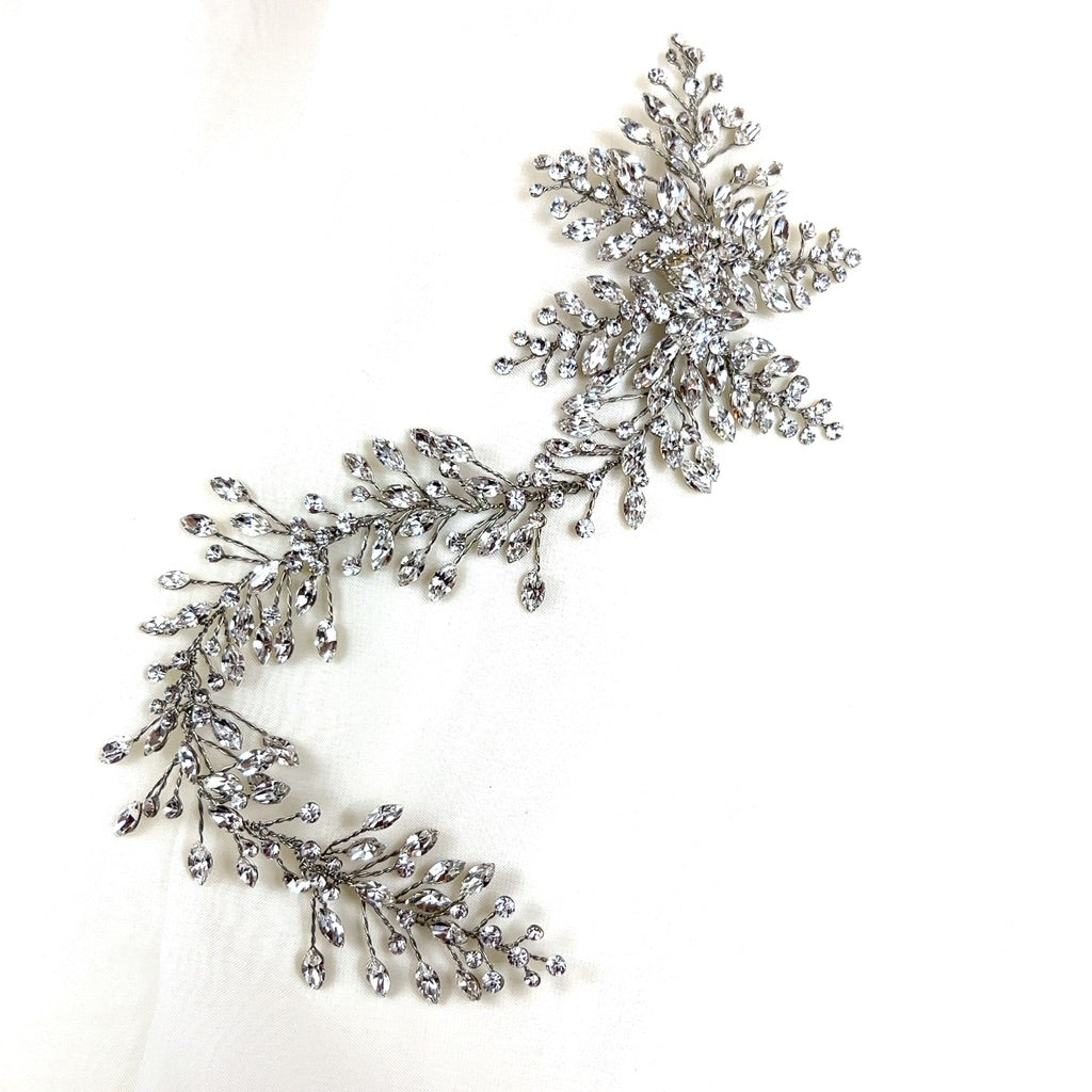 The Romantic Asymmetrical  Hair Vine (style no. 242552) is a sparkling pearl and Swarovski crystal wedding headpiece with a floral and vine design. It is displayed upon a white background. 