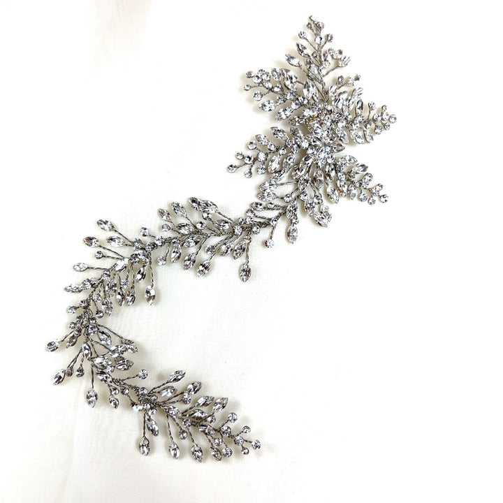 The Romantic Asymmetrical  Hair Vine (style no. 242552) is a sparkling pearl and Swarovski crystal wedding headpiece with a floral and vine design. It is displayed upon a white background. 
