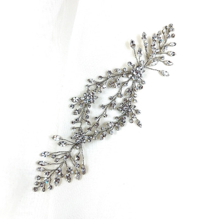 The Delicate Flowing Crystal Vine style no. 242464 is a chic Swarovski crystal hair accessory featuring an intricate motif  shaped like two leafy branches.