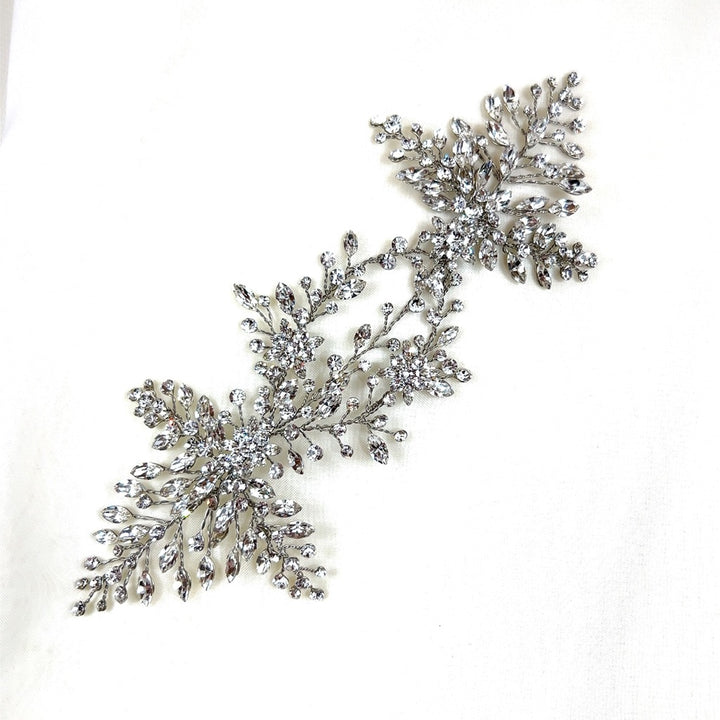 A sparkling Swarovski crystal wedding hair accessory, intricately designed with leaf and vine motifs, displayed on a white background. Product: Stunning Crystal Bridal Vine style no. 242594.