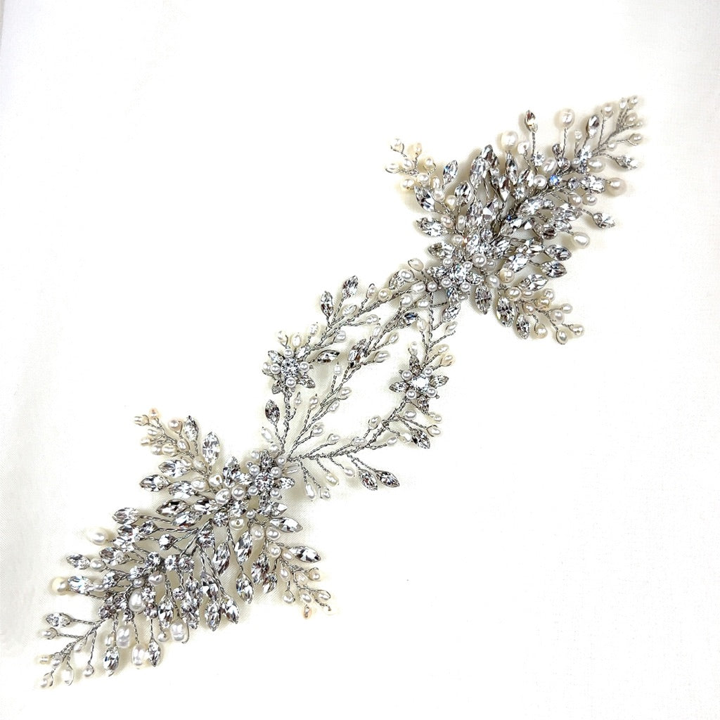 The Stunning Swarovski Crystal Bridal Hair Vine, style no. 242594, features intricate silver leaves and white pearls on a plain white background