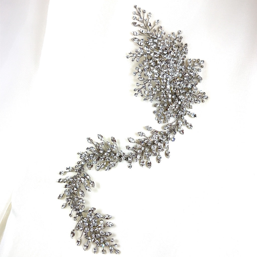 The Asymmetrical Cluster Crystal Vine (style no. 242641) features intricate branching leaf patterns covered in Swarovski crystals and at the end there is a large, broach-inspired cluster. 