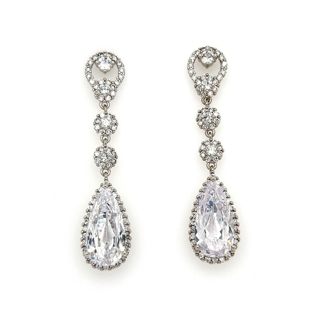 The Elegant Drop CZ Wedding Earrings (style no. E197) feature a round cluster of sparkling gems, reminiscent of a Swarovski bridal tiara, with smaller floral clusters cascading to a large pear-shaped gemstone framed by tiny stones for an exquisite finish.