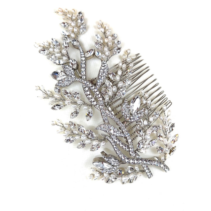 The Enchanted Forest Comb (style no. 242462) is a stunning pearl and Swarovski crystal bridal hairpiece shaped like a branch, featuring white pearls and Swarovski crystal leaves and buds, set against a white backdrop.