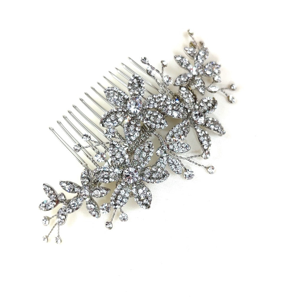 The Delicate Floral Comb, style no. 242692, is a sparkling Swarovski crystal  bridal hair comb featuring blooming flowers and delicate leaves against a plain white background.