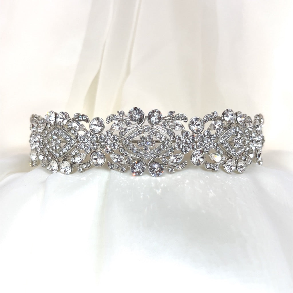 silver bridal headband with swirling floral detailing and varying sizes of round crystals