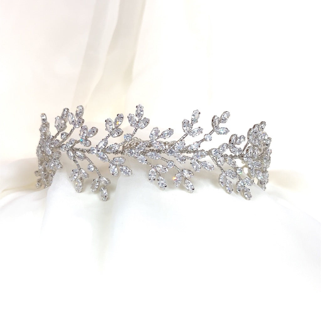 The Romantic Crystal  Bridal Headband style no. 7930116 is a delicate wedding headpiece featuring intricate leaves and sparkling Swarovski crystals, elegantly displayed on a soft white background.