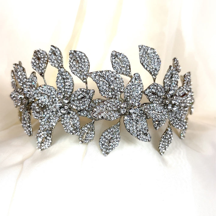 The Crystal Flower Headband (style no. 80070) is a sparkling Swarovski wedding hair accessory showcasing intricate floral and leaf designs adorned with crystals.