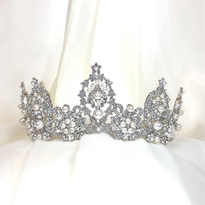silver bridal crown with various rounded crystal peaks and pearl cluster details