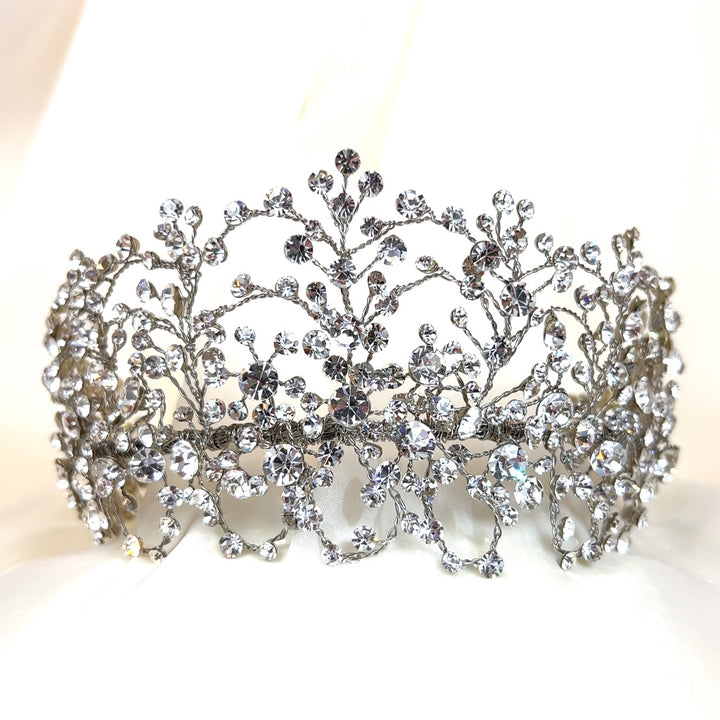 The  Classy Bridal Swarovski Crystal Bridal Headband (style no. 242676), in sparkling silver with intricate floral and branch designs in shiny crystals on a soft white background, makes the perfect accent for your special day.